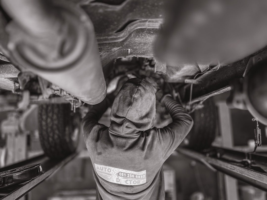 services-01 a-black-and-white-photo-of-a-man-working-on-a-vehicle-ffq4-mwzhme