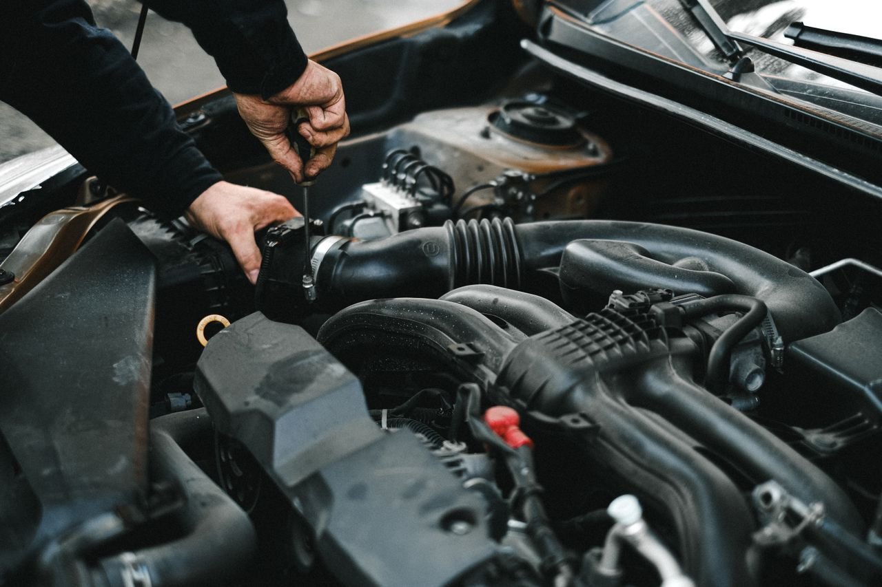 services-05 Close-up of a mechanic working on a car engine. Ideal for auto repair themes.